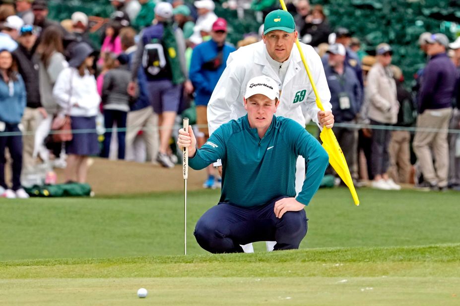 Robert MacIntyre lines up a putt with help from caddie Michael Thomson on Saturday.