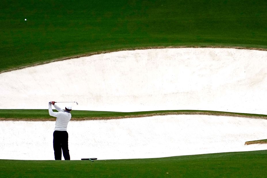 Woods plays a shot from a bunker on the eighth hole Saturday.