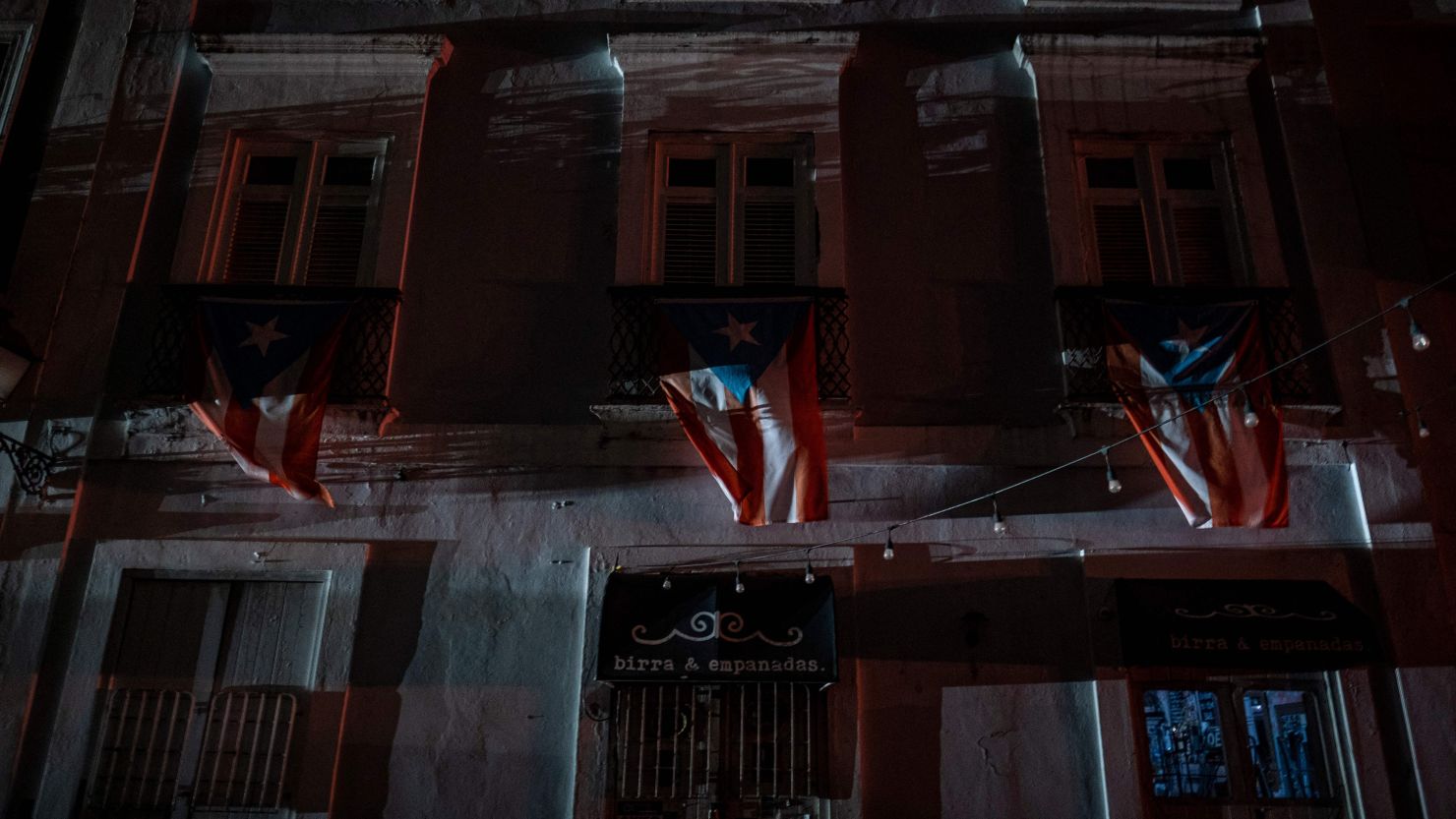 Puerto Rican flags hang from a balcony in San Juan after a major power outage hit the island Wednesday.