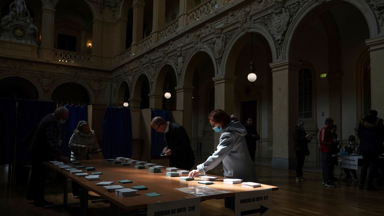 A woman picks her ballots in the first round of the French presidential election in Lyon, central France, on Sunday.