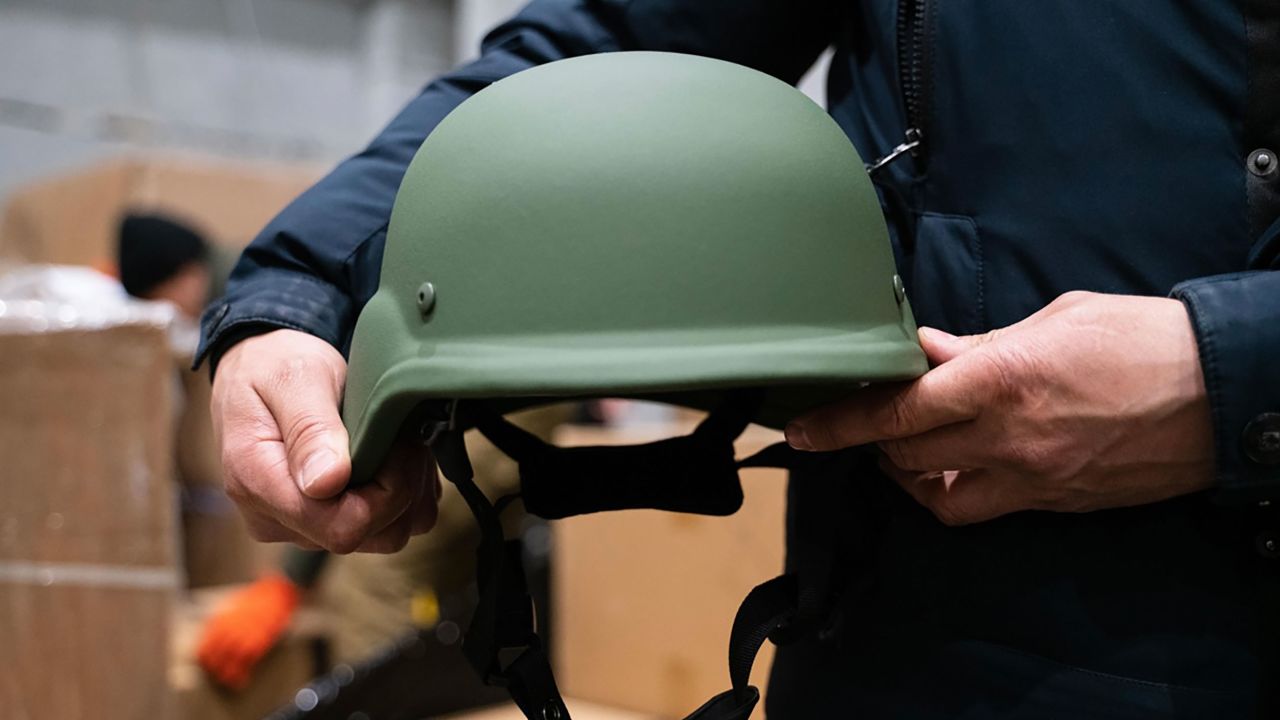 A protective helmet is held by a volunteer for the Come Back Alive foundation in one of its warehouses after a shipment of donations arrived in Ukraine.