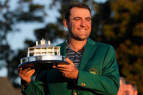 Scottie Scheffler, in his new green jacket, holds the championship trophy after winning the Masters golf tournament on Sunday, April 10.