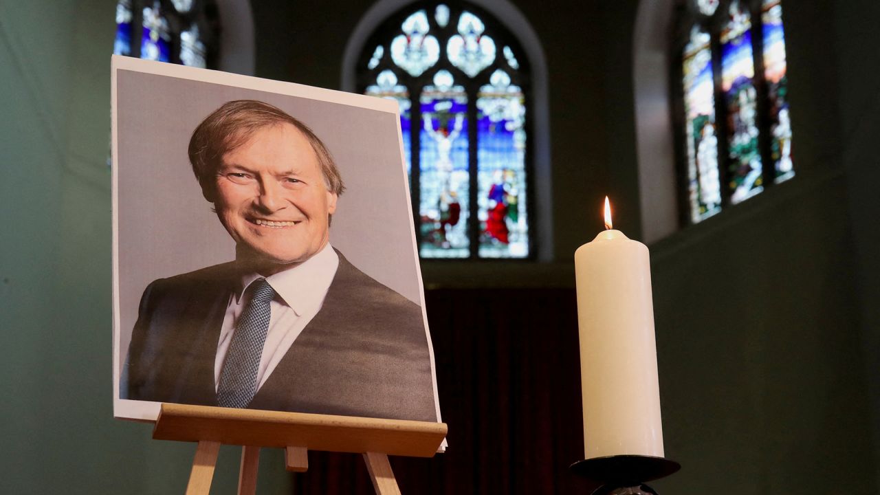 A candle and a portrait of British MP David Amess, who was stabbed to death during a meeting with constituents, are seen at the church of St. Michael and All Angels, in Leigh-on-Sea on October 17, 2021. 