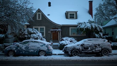 A house and vehicles are seen covered in snow on North Vancouver Avenue in Portland, Oregon, on Monday morning.