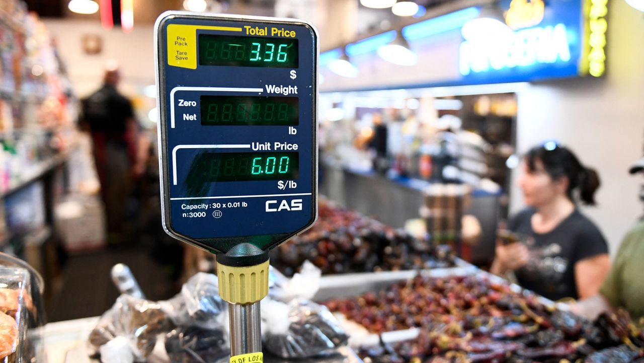 A clerk weighs dried peppers for a customer inside Grand Central Market on March 11, 2022 in downtown Los Angeles, California.