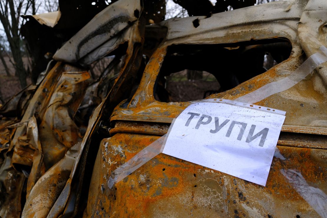 A sign taped to a burned out car reads "corpses" in Ukrainian, telling search teams where to look for bodies.