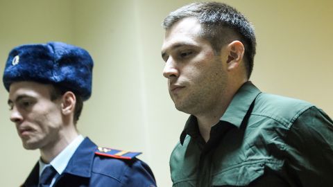 Police officers escort former US Marine Trevor Reed into a courtroom before a March 2020 hearing in Moscow. 