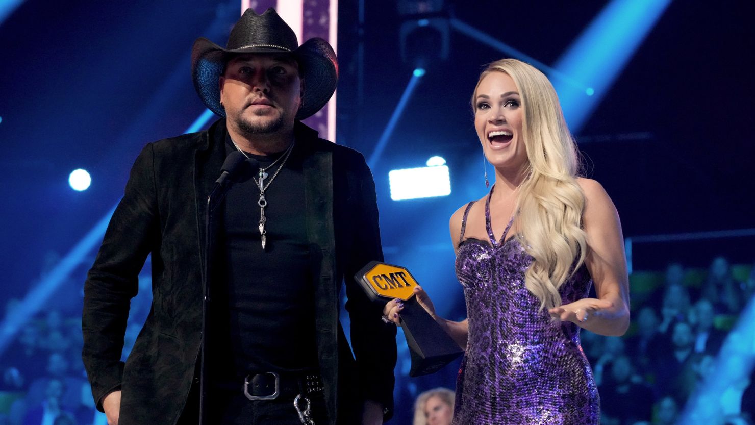 Jason Aldean and Carrie Underwood accept an award for collaborative video of the year onstage at the 2022 CMT Music Awards on Monday.