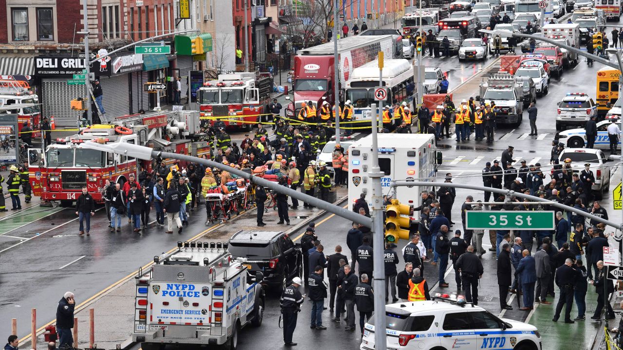 Members of the New York Police Department and emergency vehicles crowd the streets after at least 13 people were injured during a rush-hour shooting at a subway station in the New York borough of Brooklyn on April 12, 2022, where authorities said "several undetonated devices" were recovered amid chaotic scenes. 