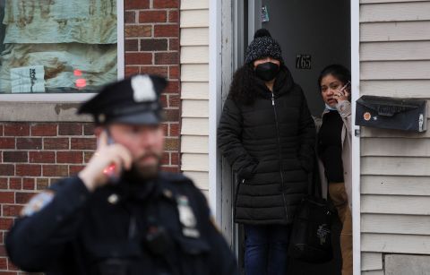 People look out of a home near the scene of the shooting.