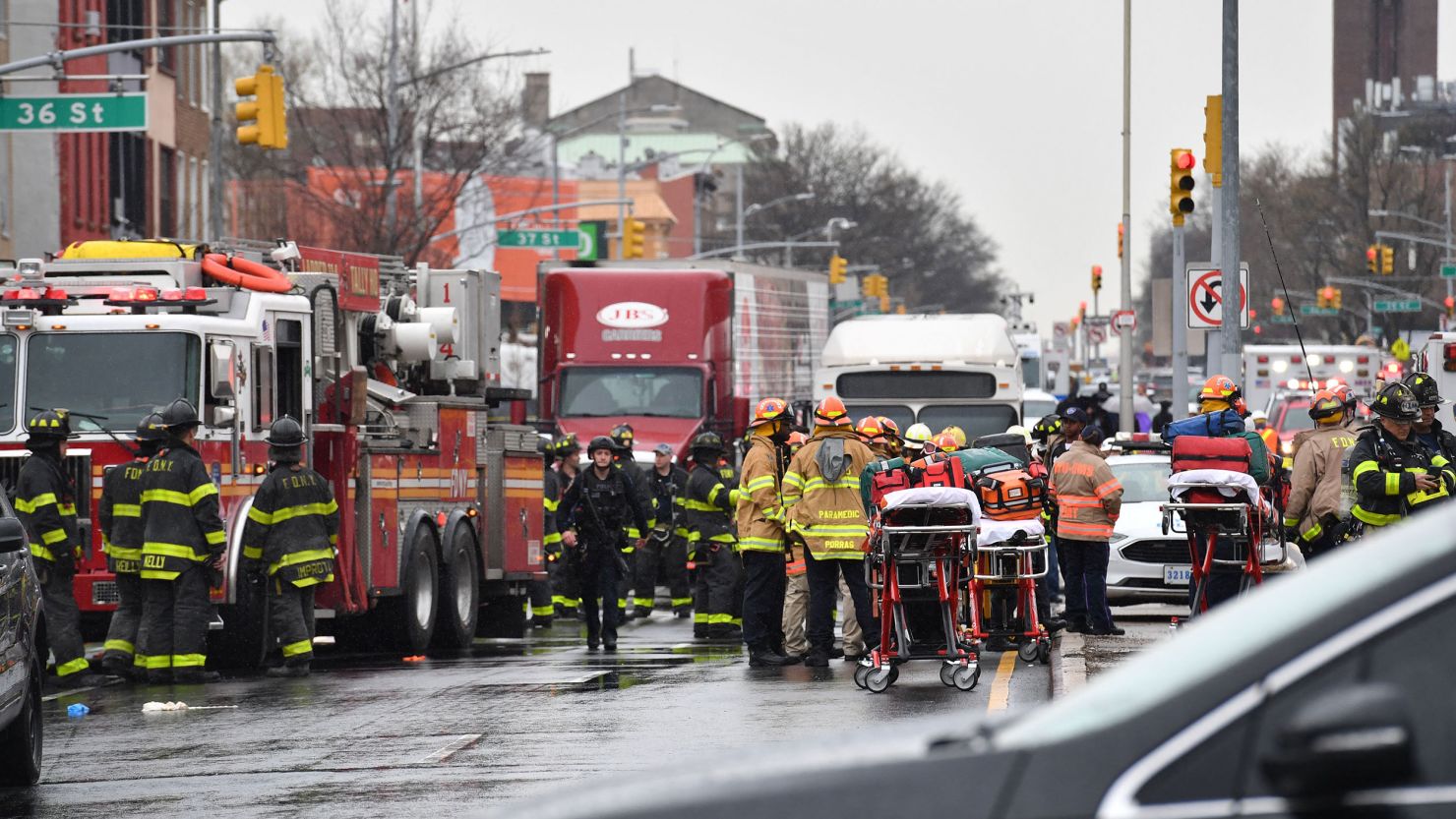 Members of the New York Police Department and emergency personnel crowd the streets near a subway station in the New York City borough of Brooklyn on Tuesday, April 12, 2022.