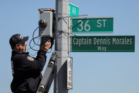 A New York City police officer checks security cameras near the scene.