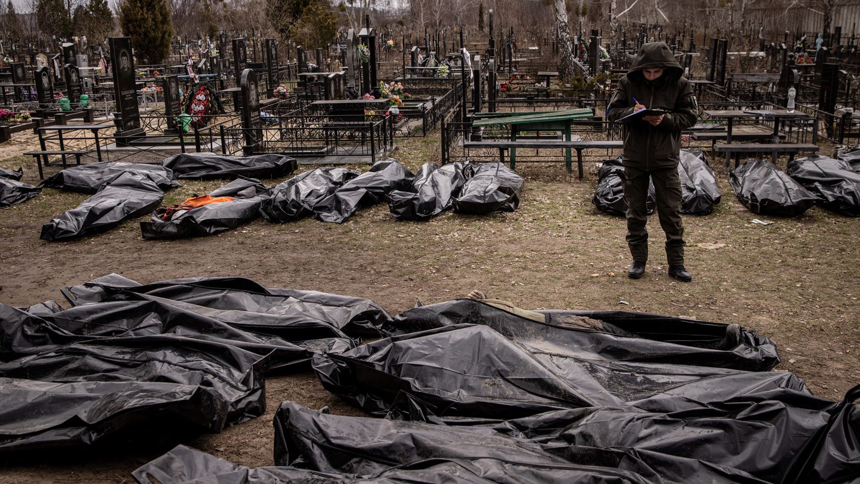 A man works to catalog some of 58 bodies of civilians killed in and around Bucha before they are transported to the morgue at a cemetery on April 6, 2022 in Bucha, Ukraine. 