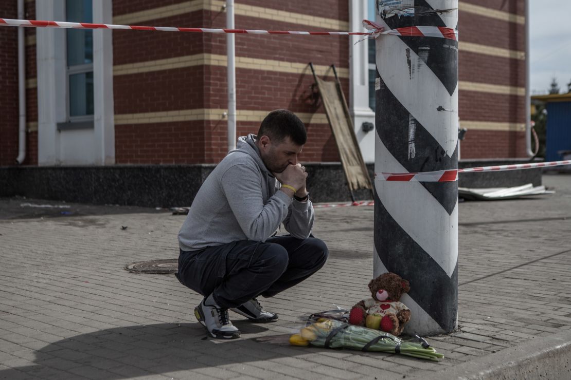 A man lays flowers at a memorial at Kramatorsk railway station.