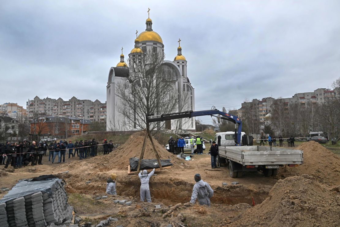 Journalists gather as bodies are exhumed from a mass grave in the grounds of St. Andrew and Pyervozvannoho All Saints church in Bucha, Ukraine, on April 13, 2022. 