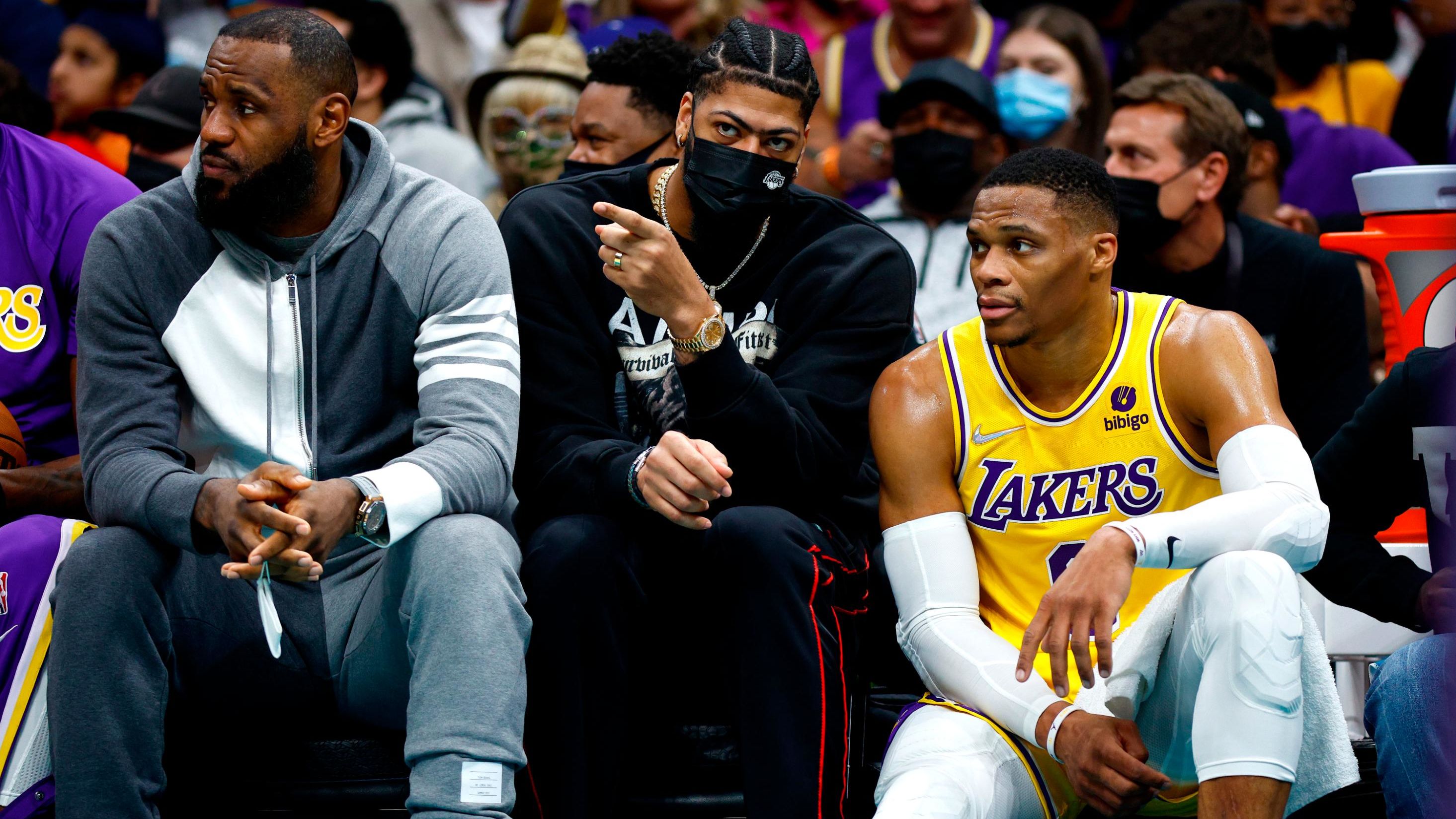 LeBron James, Anthony Davis and Russell Westbrook look on from the sidelines during the Lakers' game against the Charlotte Hornets at Spectrum Center on January 28, 2022 in Charlotte.