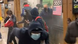 In this photo from social media video, passengers run from a subway car in a station in the Brooklyn borough of New York, Tuesday, April 12, 2022. A gunman filled a rush-hour subway train with smoke and shot multiple people Tuesday, leaving wounded commuters bleeding on a Brooklyn platform as others ran screaming, authorities said. Police were still searching for the suspect. (Will B Wylde via AP)