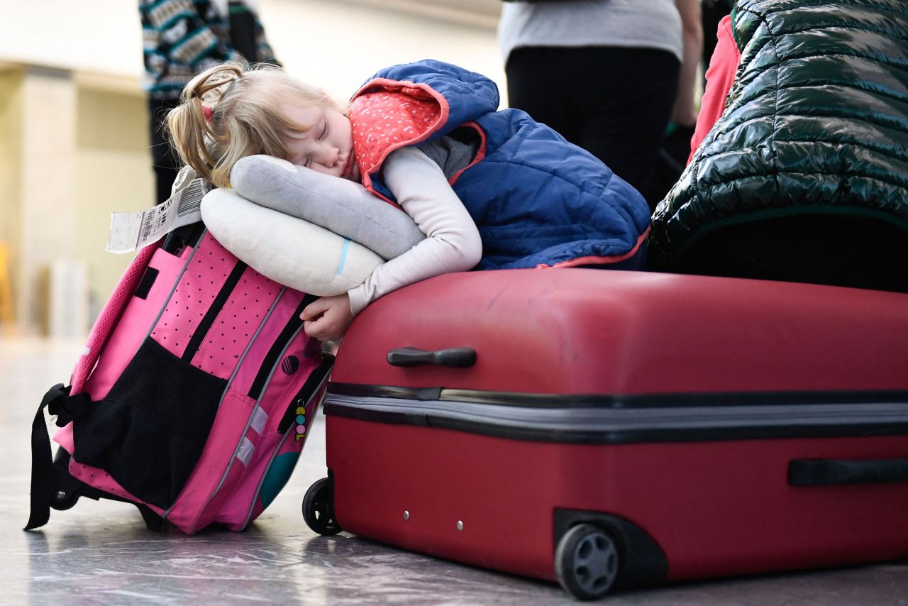 Anna Kuts, 3, sleeps on a suitcase after arriving at the Tijuana airport with her family on April 8.