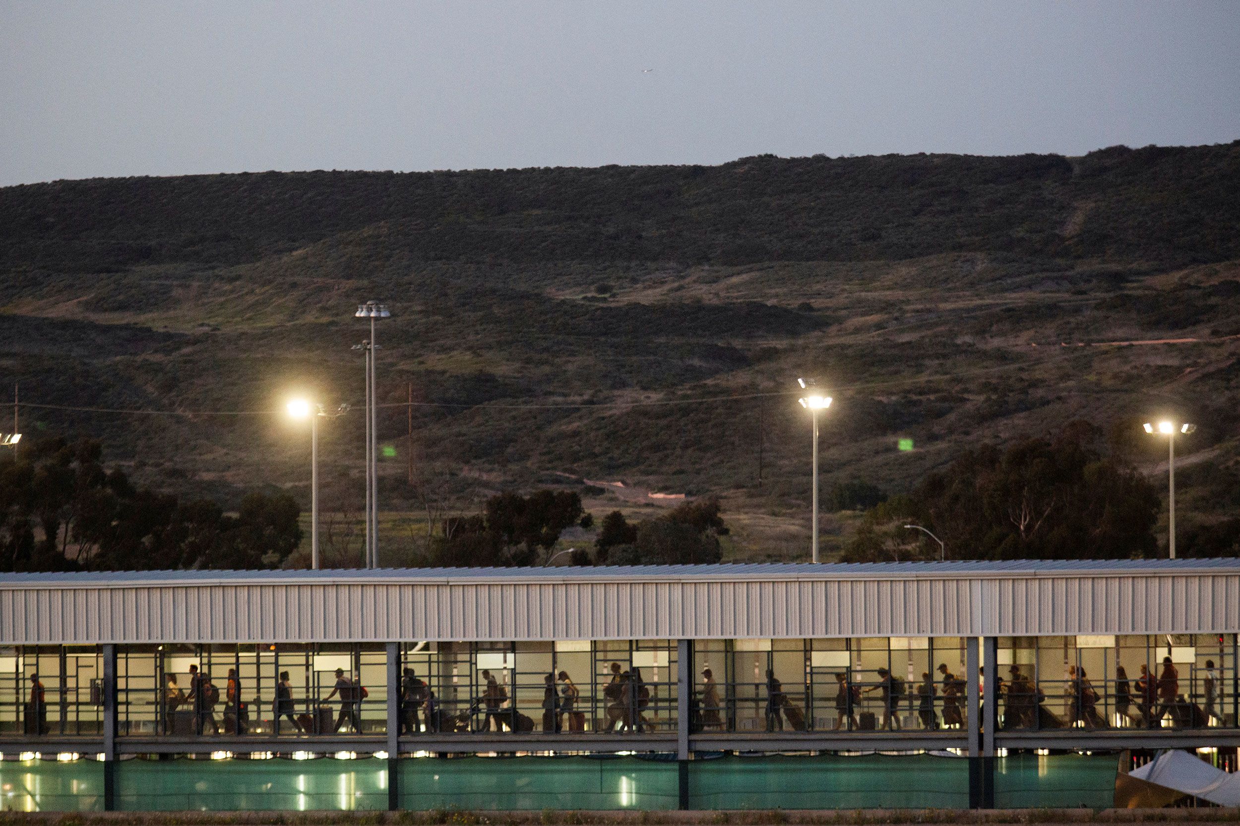 Ukrainians file through the El Chaparral port of entry in Tijuana to cross into the US on April 8. Officials recently reopened this border crossing to process arriving Ukrainians, according to Enrique Lucero, Tijuana's director of migrant affairs.