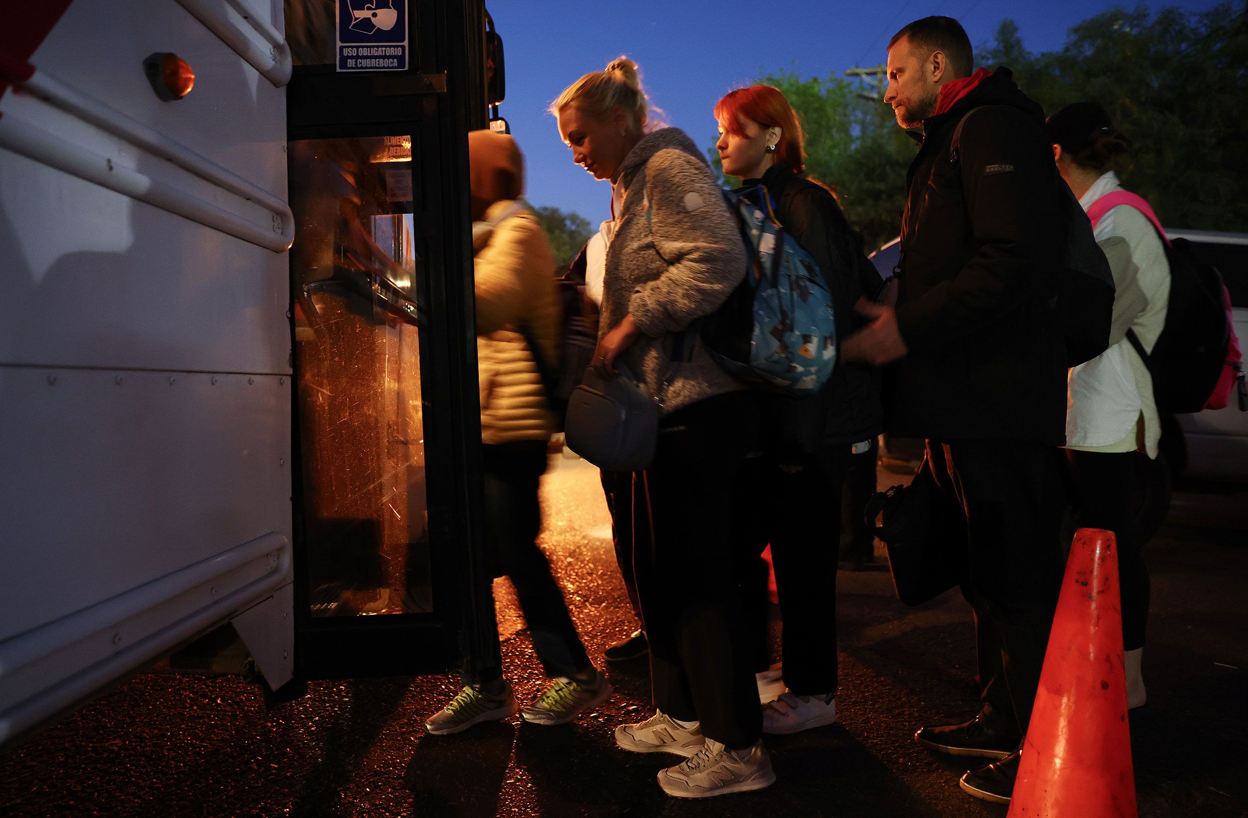 Ukrainians who are seeking asylum board a bus at dawn on April 7 as they head to the El Chaparral port of entry.