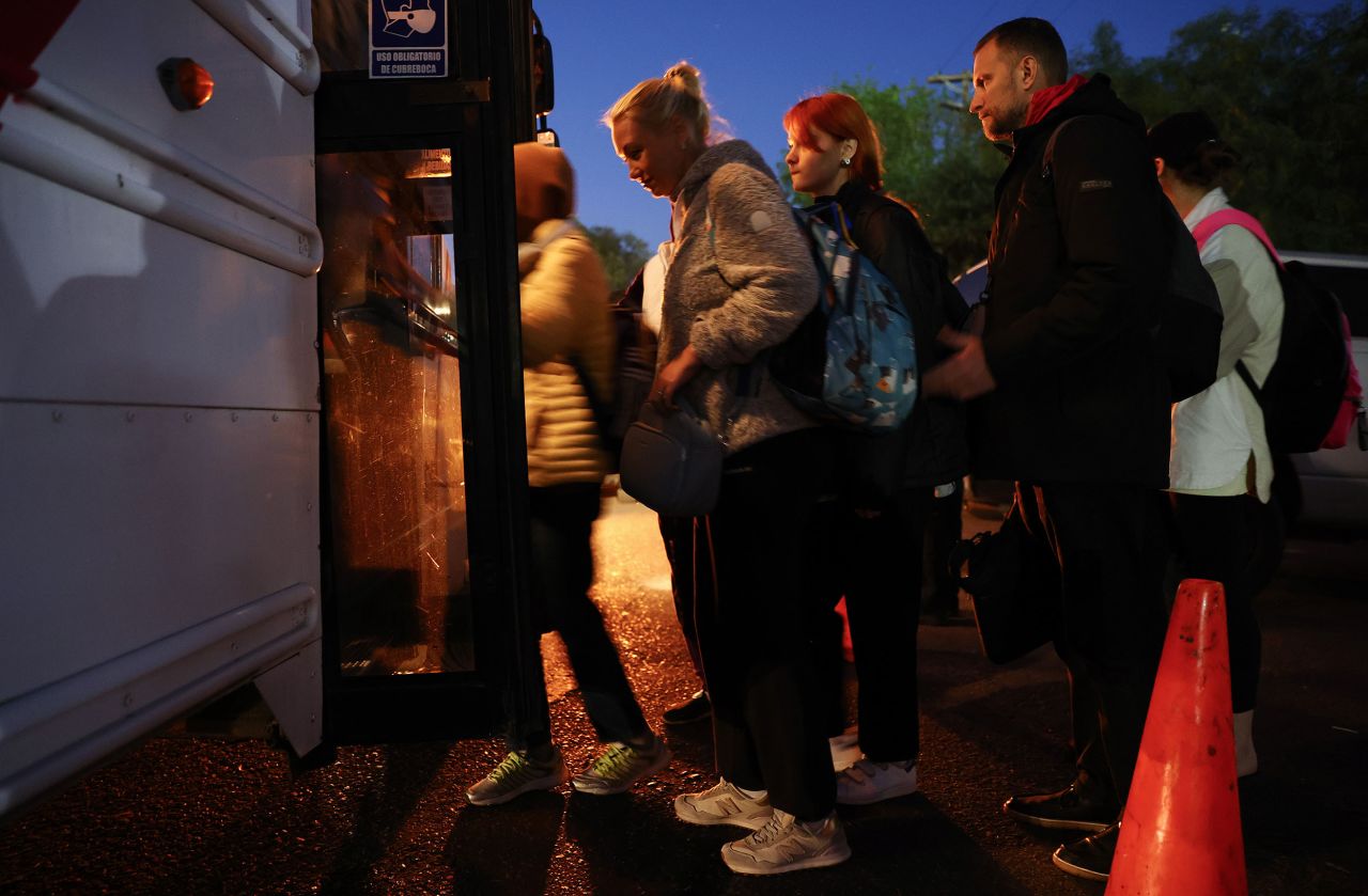 Ukrainians who are seeking asylum board a bus at dawn on April 7 as they head to the El Chaparral port of entry, where they hope to cross into the United States.