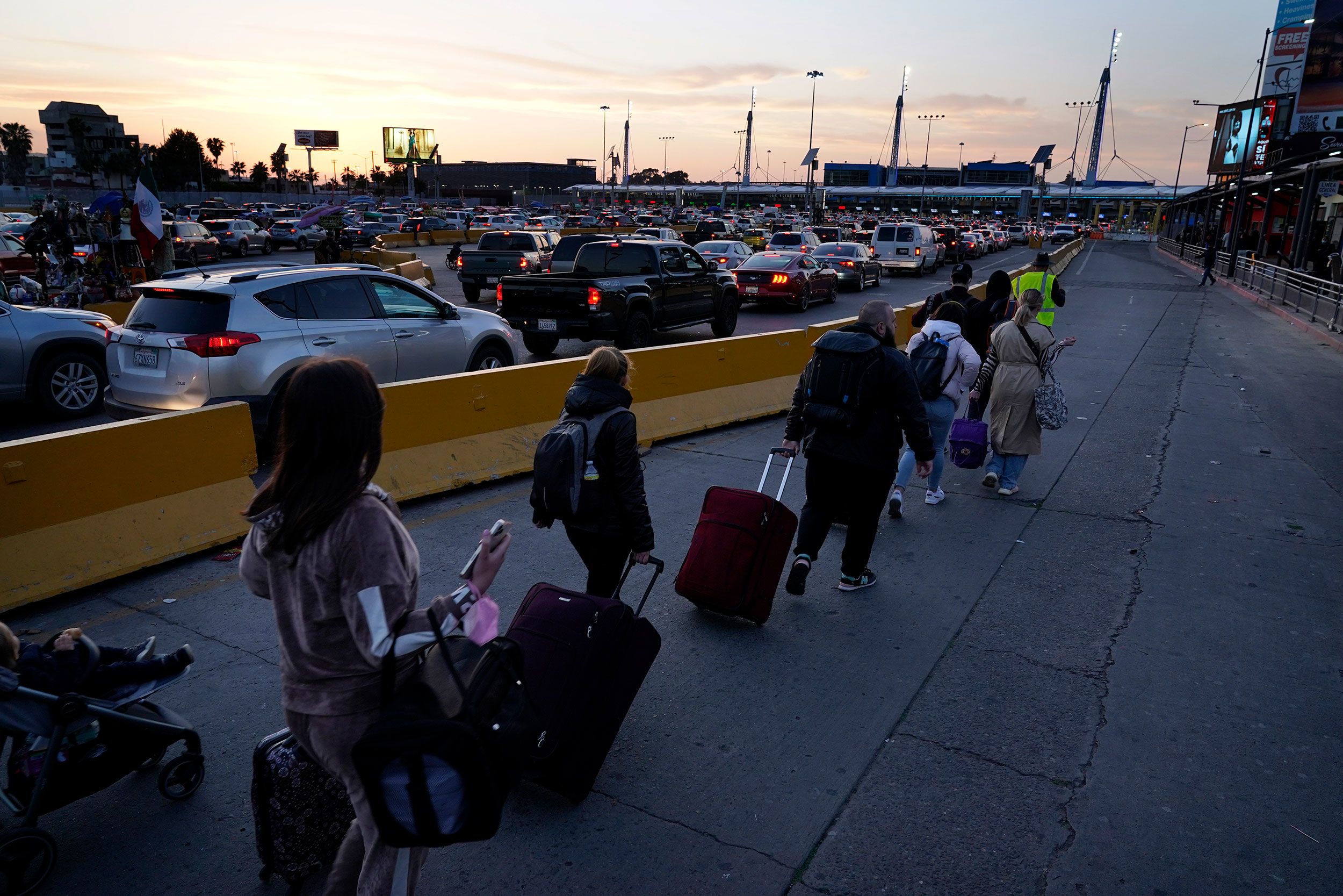 Ukrainians follow a volunteer to the San Ysidro Port of Entry as they prepare to cross into the United States.