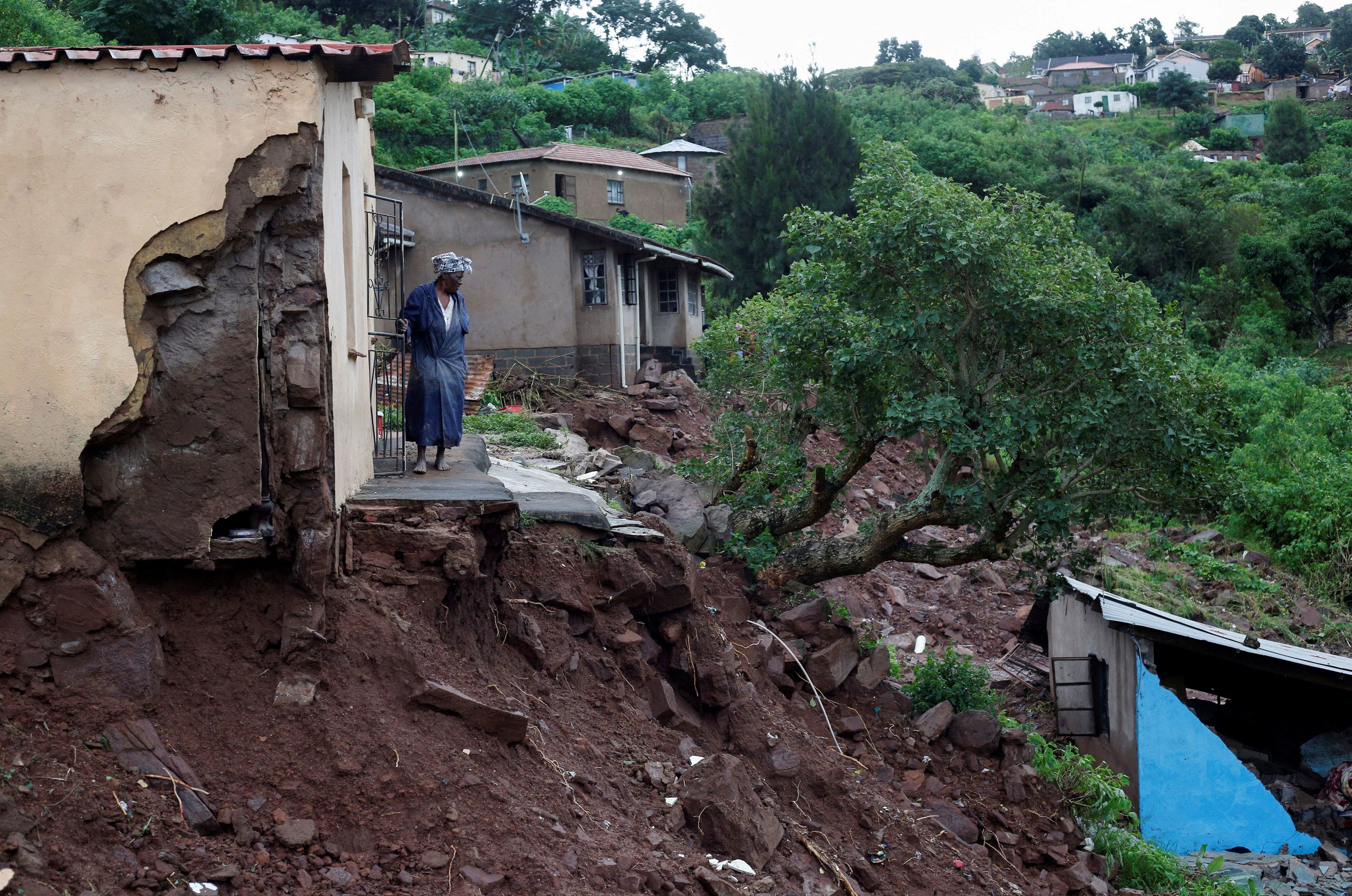 A woman stands at her front door in Durban, South Africa, on Tuesday, April 12. Heavy rains and flooding battered the eastern coast of South Africa.