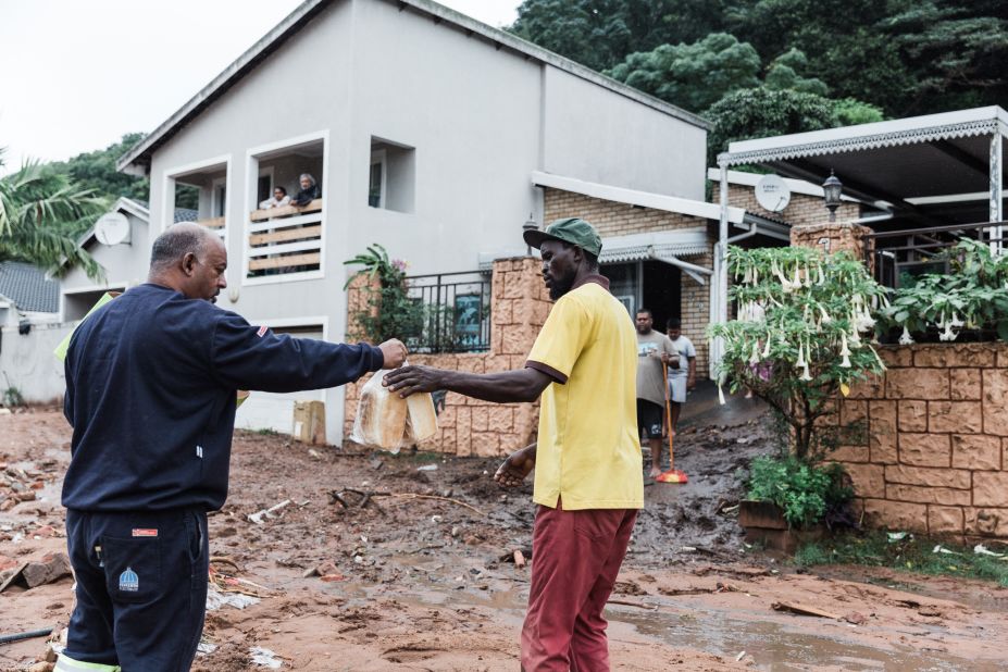 A volunteer hands two loaves of bread to a man in Durban on April 12. 