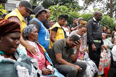 People grieve at a church in Clermont after four children died following heavy rains and floods. Mmeli Sokhela, center, lost four children when the church collapsed onto his home.