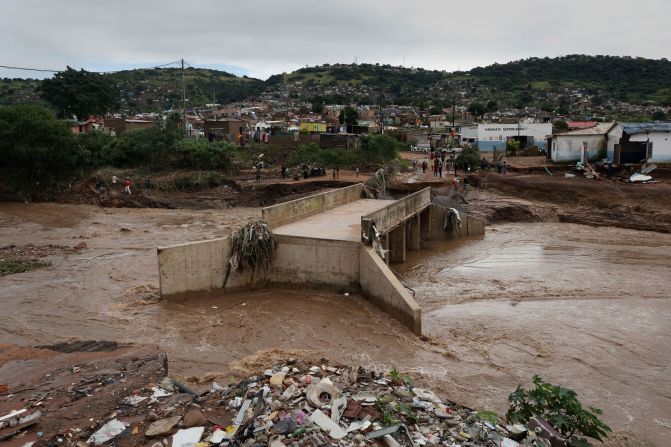 A river runs around a damaged bridge on April 12 after heavy rains destroyed it near Durban.