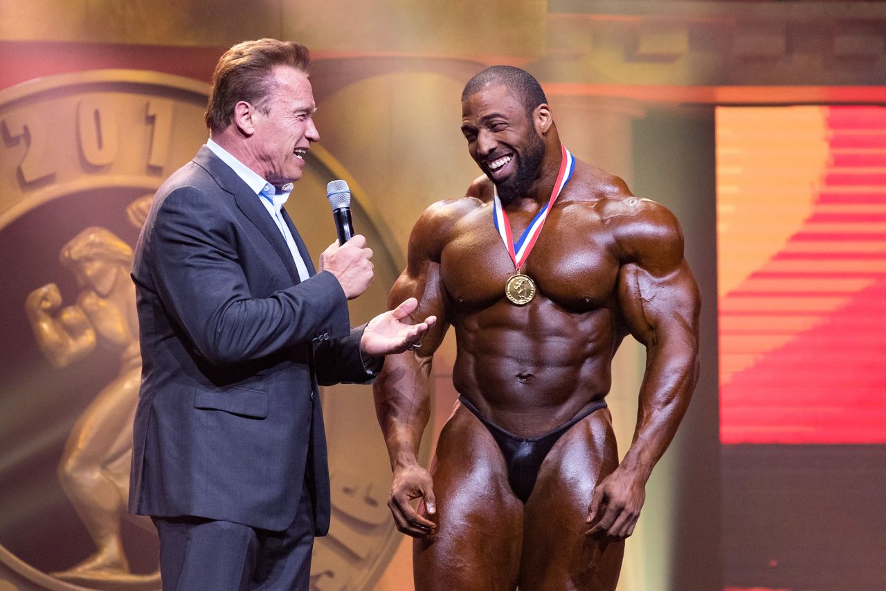 Star bodybuilder Cedric McMillan, seen here being interviewed by Arnold Schwarzenegger, died at the age of 44, his sponsor confirmed on April 12. McMillan won multiple titles during his career, including the 2017 Arnold Classic. No further details were released about his death.