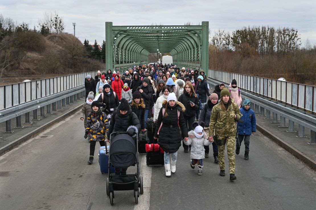 Ukrainian refugees cross a bridge in Ukraine near the Polish border on March 6, 2022.