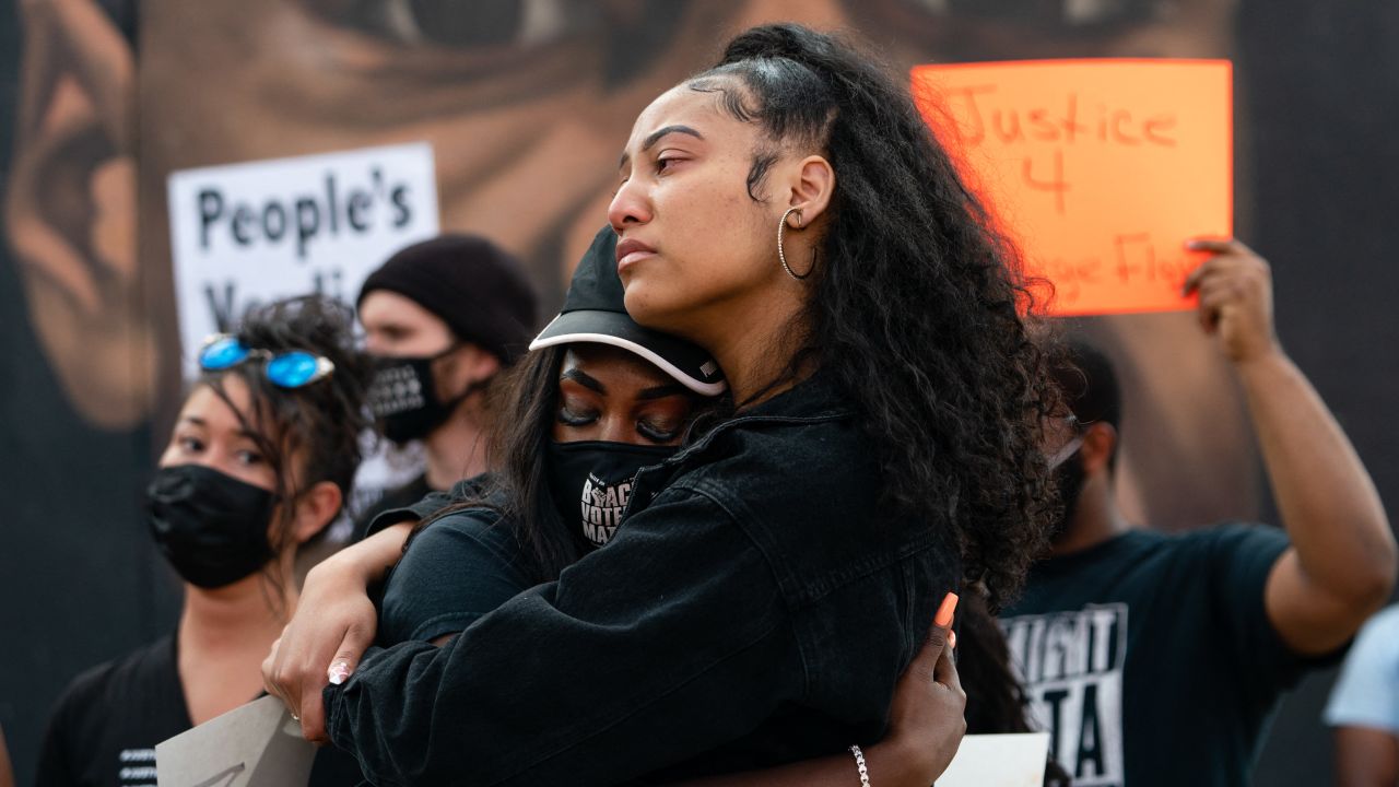 Two women embrace in front of a mural of George Floyd following the guilty verdict the trial of Derek Chauvin on April 20, 2021, in Atlanta, Georgia.