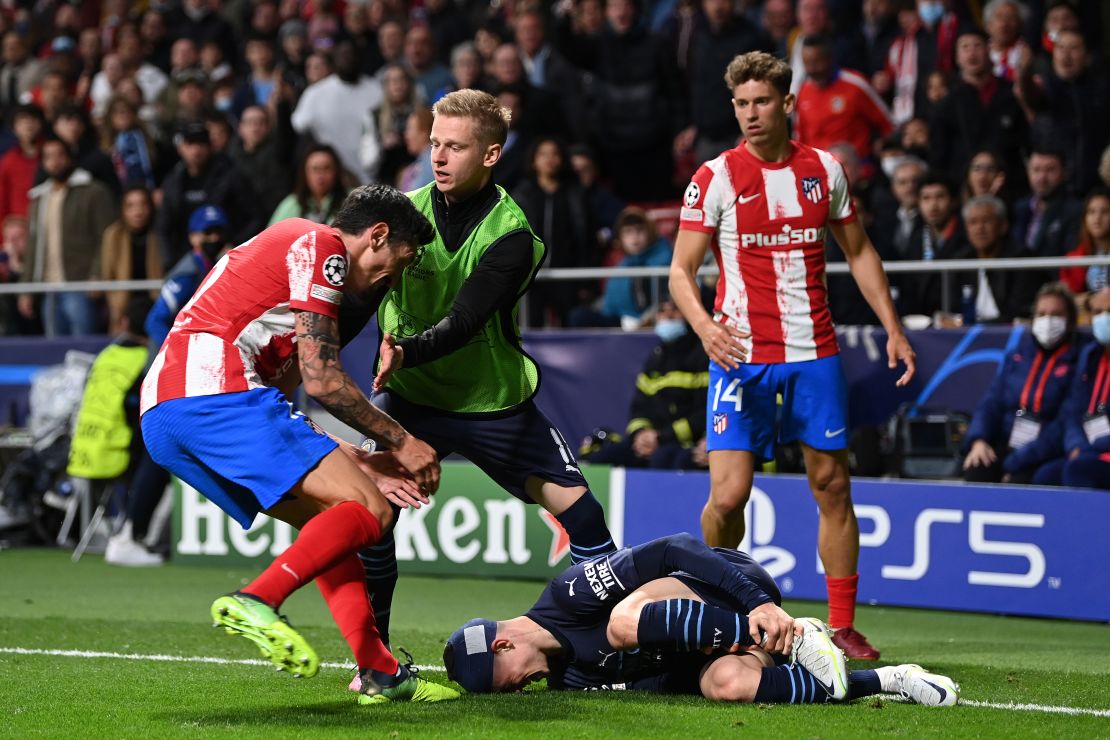 Oleksandr Zinchenko holds off Stefan Savić of Atlético Madrid as Phil Foden is seen on the floor.
