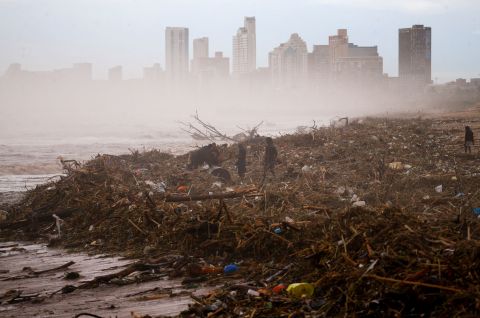 People search for salvageable items on the beach in Durban on April 12.