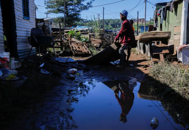 People drag a carpet into the sun to dry after their home was flooded in Isipingo Beach.