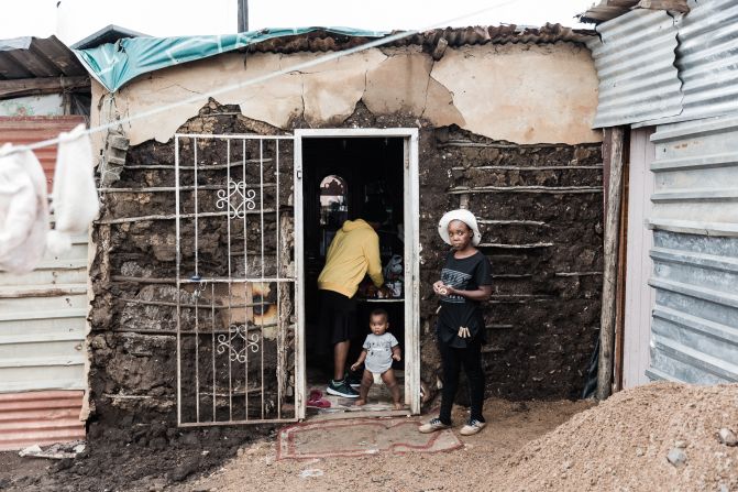 Residents stand in front of their damaged home in the Bhambayi township on April 13.