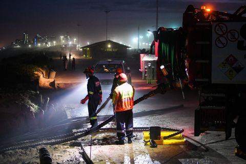 A worker cleans up a tanker that washed up on a Durban beach on Tuesday, April 12.