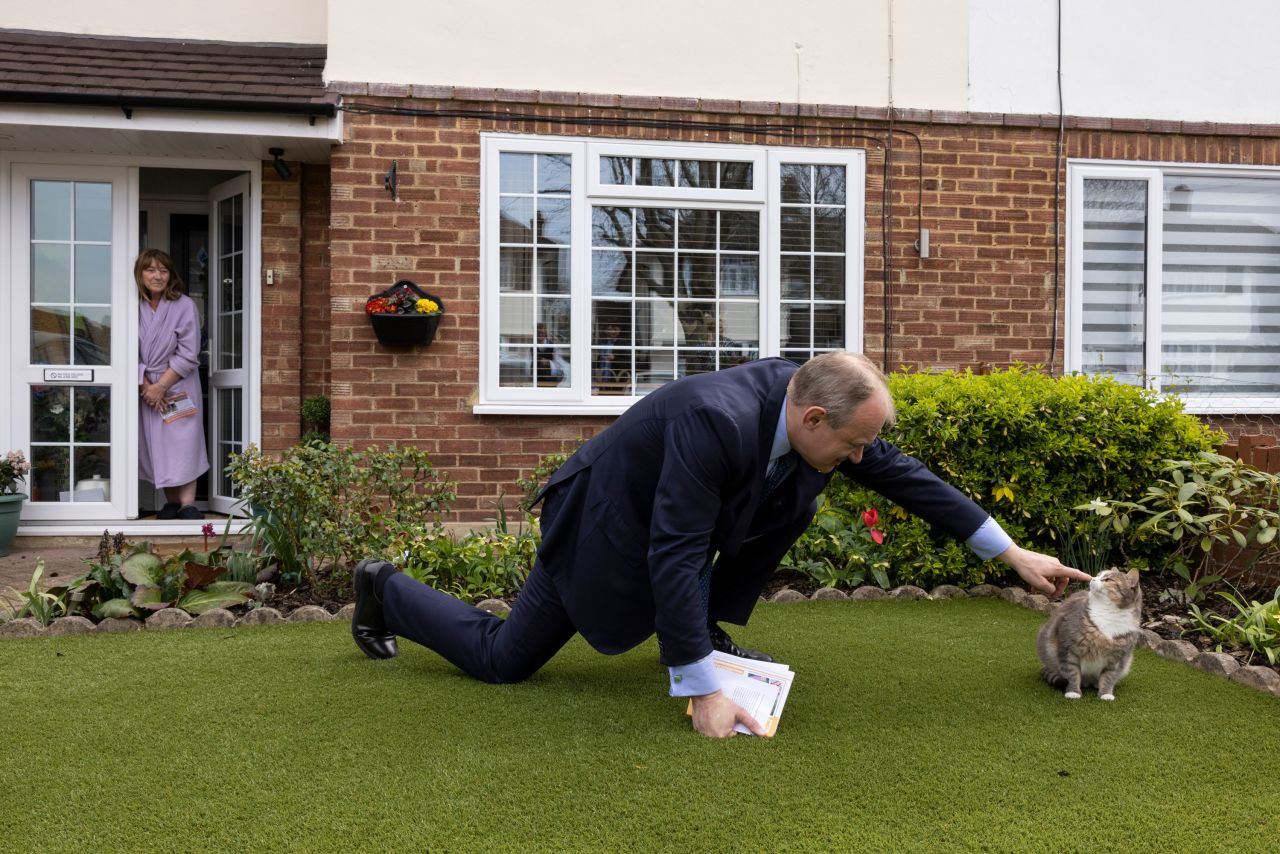 Ed Davey, a member of the UK Parliament, tries to pet Mikee the cat while canvassing in Watford, England, on Tuesday, April 12.