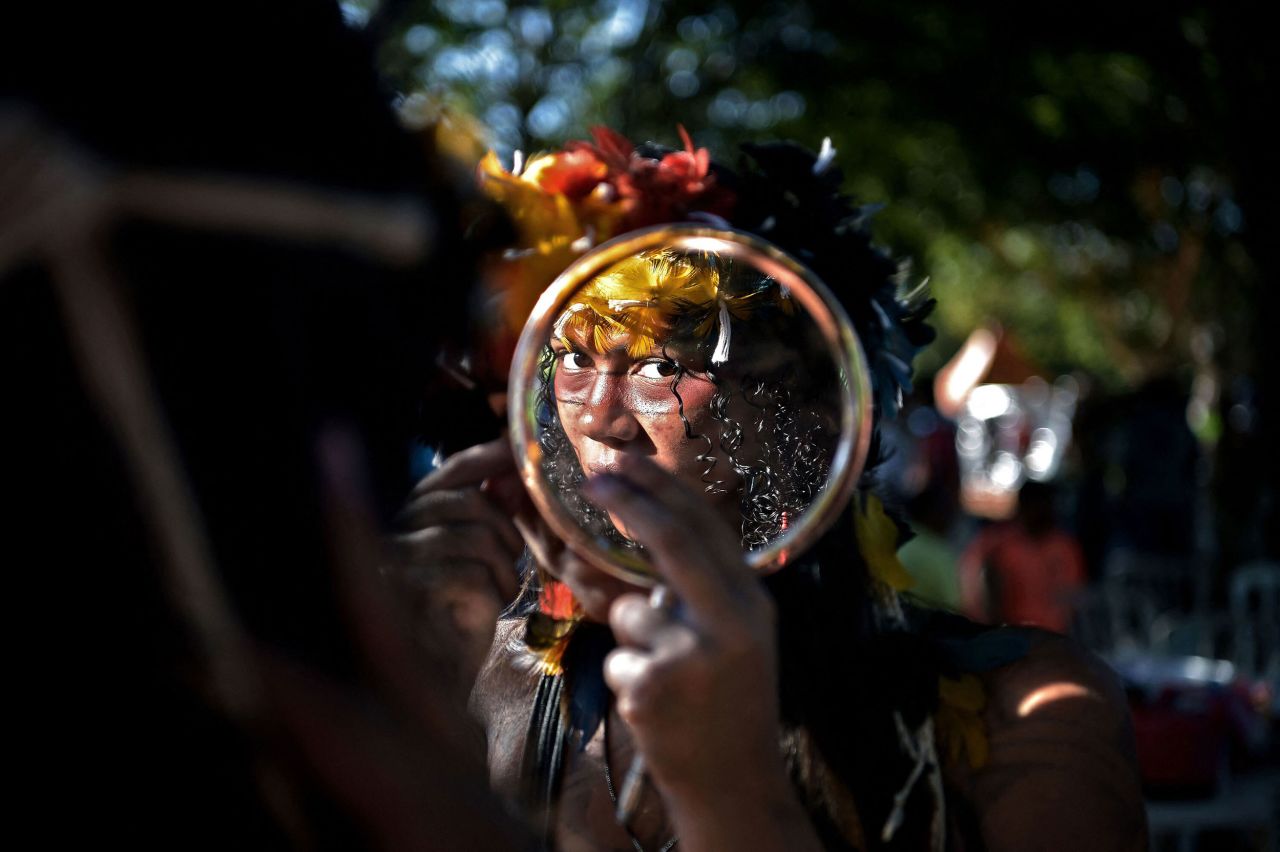 A woman with the Truka tribe looks at herself in the mirror as she takes part in the annual Terra Livre Indigenous Camp protest in Brasilia, Brazil, on Thursday, April 7. The 10-day gathering is held by indigenous people from tribes all over Brazil, and they use the event to call for greater protection of their land and rights.