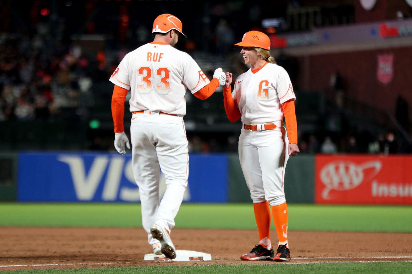 Darin Ruf, a baseball player with the San Francisco Giants, fist-bumps Alyssa Nakken as she served as the team's first-base coach on Tuesday, April 12. It was <a href="index.php?page=&url=https%3A%2F%2Fwww.espn.com%2Fmlb%2Fstory%2F_%2Fid%2F33727846%2Falyssa-nakken-31-makes-major-league-history-first-woman-coach-field-regular-season-game-san-francisco-giants" target="_blank" target="_blank">the first time in Major League history</a> that a woman had taken the field to coach during a regular-season game.