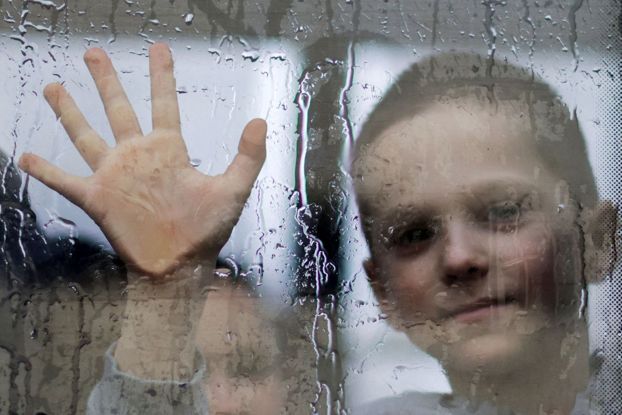 A boy waves goodbye to his father through a window as he flees Zaporizhzhia, Ukraine, on Wednesday, April 13.
