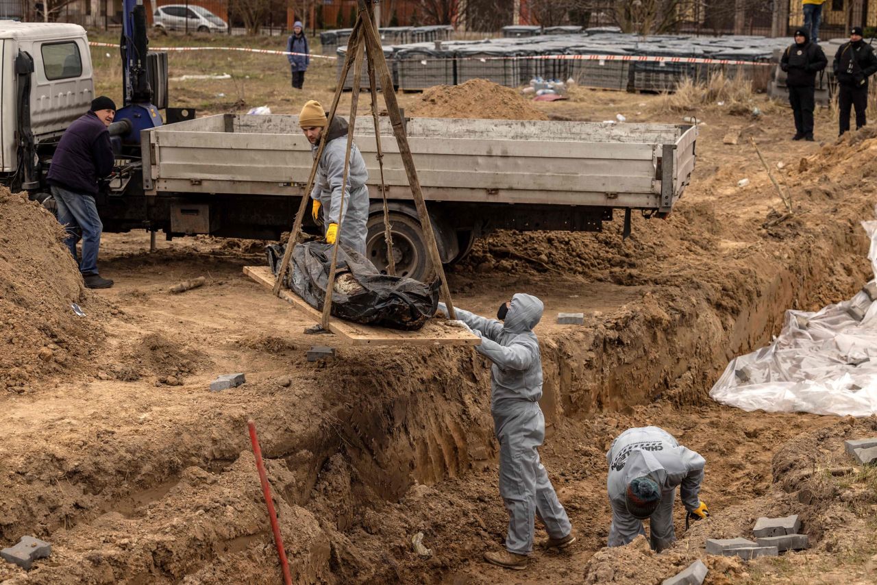 Workers exhume bodies at a site in Bucha, Ukraine, on Wednesday, April 13. The bodies of civilians in Bucha, a suburb of Kyiv, <a href="https://www.cnn.com/2022/04/03/europe/bucha-ukraine-civilian-deaths-intl/index.html" target="_blank">sparked international outrage</a> and raised the urgency of ongoing investigations into alleged Russian war crimes. Ukrainian President Volodymyr Zelensky called on Russian leaders to be held accountable for the actions of the nation's military. The Russian Ministry of Defense, without evidence, claimed the extensive footage of Bucha was "fake."