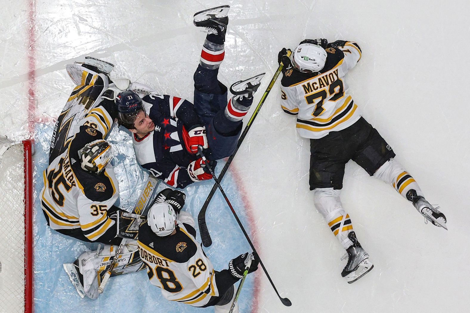 Washington's Garnet Hathaway collides with Boston goalie Linus Ullmark during an NHL game in Washington, DC, on Sunday, April 10. 