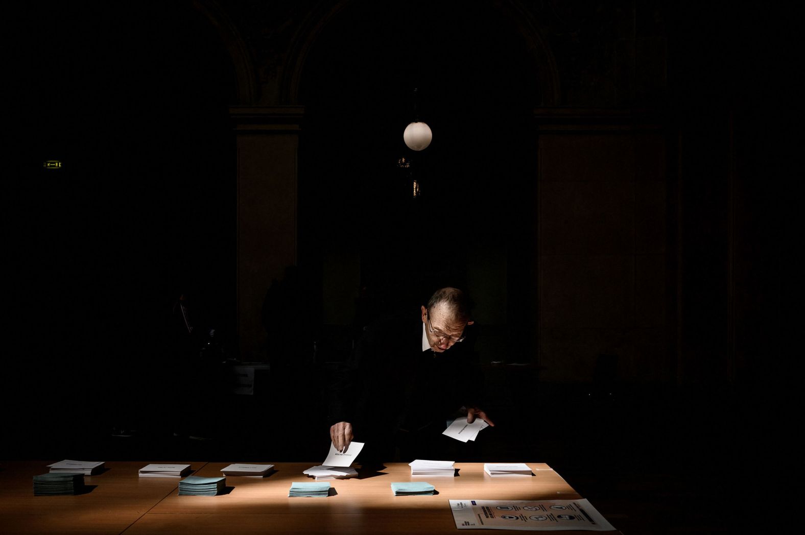 A voter in Lyon, France, picks up ballots for the first round of France's presidential election on Sunday, April 10.