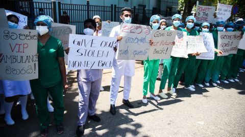 Health workers hold placards during a demonstration against the island's deepening economic crisis in Colombo on April 6, 2022.