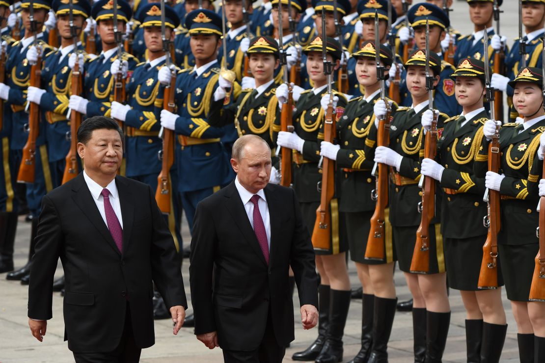 Chinese President Xi Jinping and Russian leader Vladimir Putin review a military honor guard outside the Great Hall of the People in Beijing on June 8, 2018. 