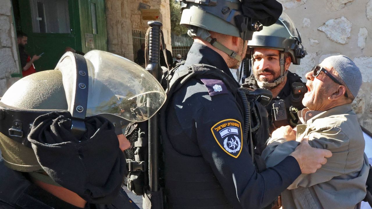 Israeli security forces scuffle with a Palestinian man as he tries to enter the al-Aqsa mosque compound to attend Friday prayers on April 15, 2022.