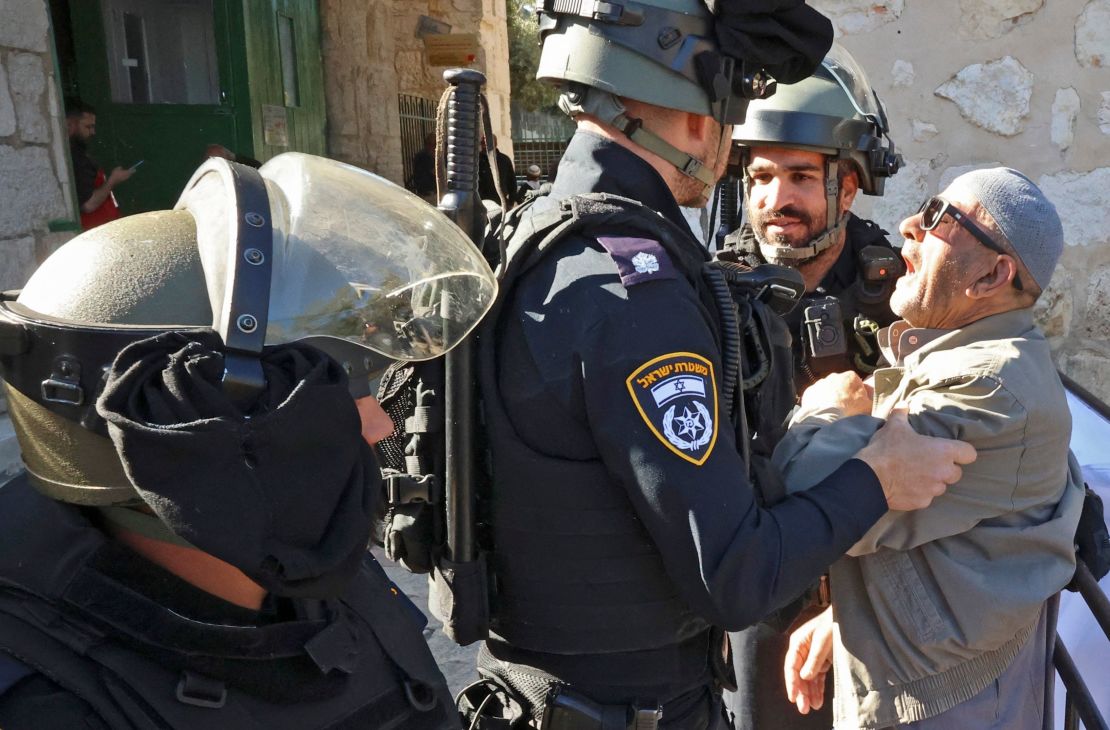 Israeli security forces scuffle with a Palestinian man as he tries to enter the al-Aqsa mosque compound to attend  Friday prayers on April 15, 2022.
