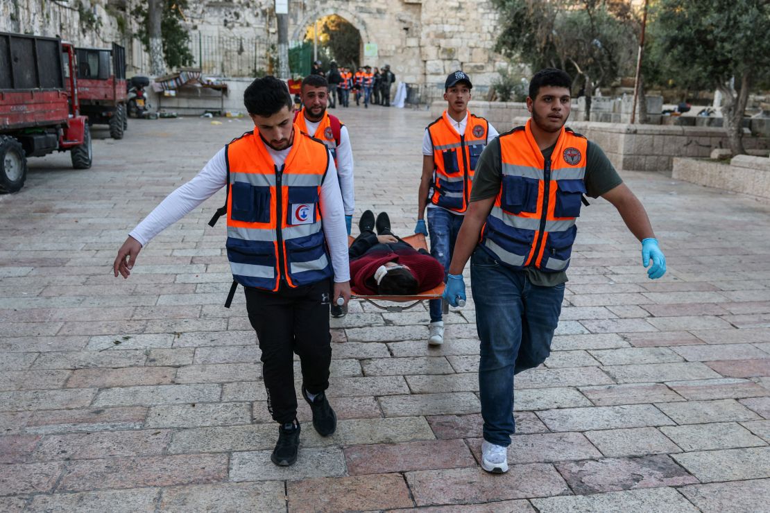 Rescuers evacuate an injured man as Palestinian demonstrators and Israeli police clash at Jerusalem's al-Aqsa mosque compound on April 15, 2022.